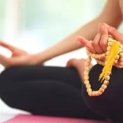 Person in Meditation, Hände halten Mala-Kette, um den perfekten Mantra finden zu können.