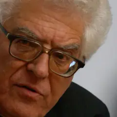 Nahaufnahme eines älteren Mannes mit Brille und weißem Haar, der nachdenklich in die Kamera blickt. Franz Grave, ein Mann mit tiefen Falten und einem ernsten Ausdruck.