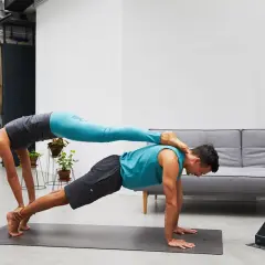 Paar übt anspruchsvolle Acroyoga Figuren. Sie bilden eine stabile Basis für kreative Posen.