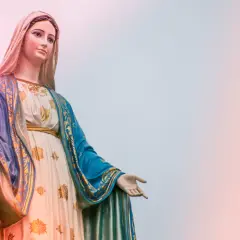 Statue der Maria, die ihre Hand ausstreckt, als würde sie zu einer Marienandacht im Mai einladen.