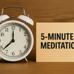 Ein Wecker zeigt 8 Uhr. Daneben liegt ein Zettel mit "5-MINUTEN-MEDITATION". So einfach kann es sein, wie meditiert man.
