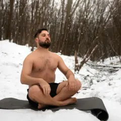 Mann in der Kälte, übt Wim Hof Atmung im Schnee.