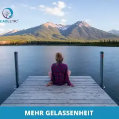 Eine Frau sitzt auf einem Steg am See, blickt auf Berge. Ähnlich gelassen wie Kardinal Ratzinger in stiller Kontemplation.
