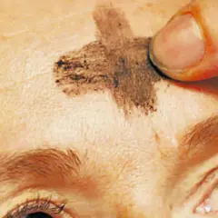 Ein Finger zeichnet ein Aschekreuz auf die Stirn. Dies ist ein Symbol für Aschermittwoch und den Beginn der Fastenzeit.