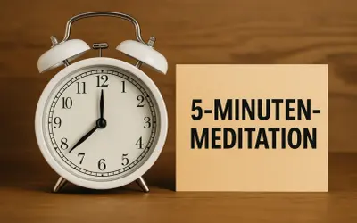 Ein Wecker zeigt 8 Uhr. Daneben liegt ein Zettel mit "5-MINUTEN-MEDITATION". So einfach kann es sein, wie meditiert man.