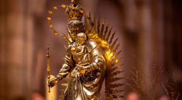 Goldene Statue der Maria mit Kind, gekrönt und mit Sternenhalo. Ein Symbol für Hoffnung und Glauben, das viele Namen trägt.