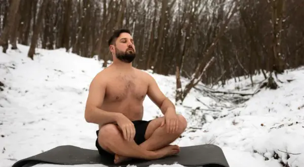 Mann in der Kälte, übt Wim Hof Atmung im Schnee.