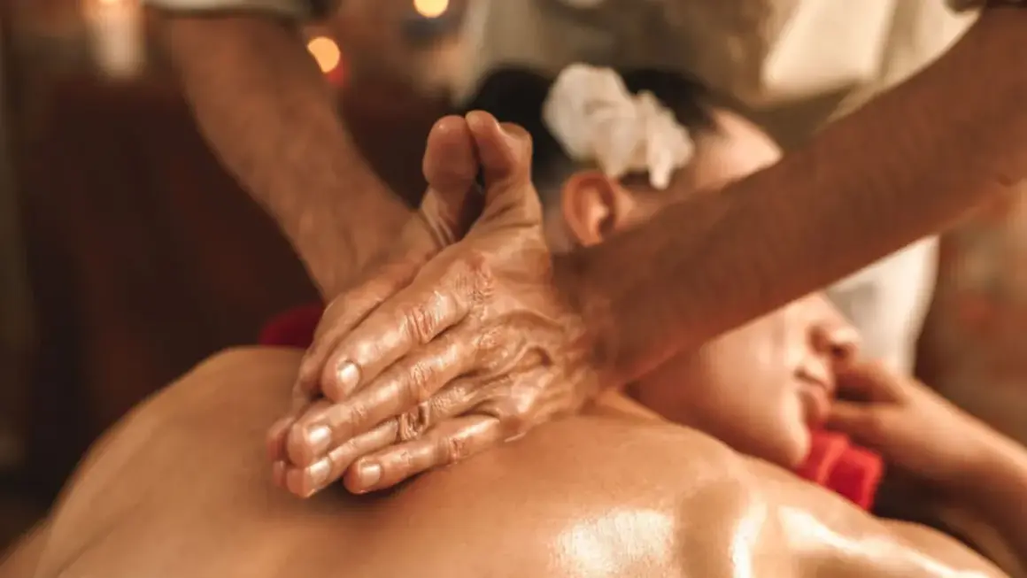 Hände massieren geölt den Rücken einer Person. Eine sanfte ayurveda abhyanga massage zur Entspannung.