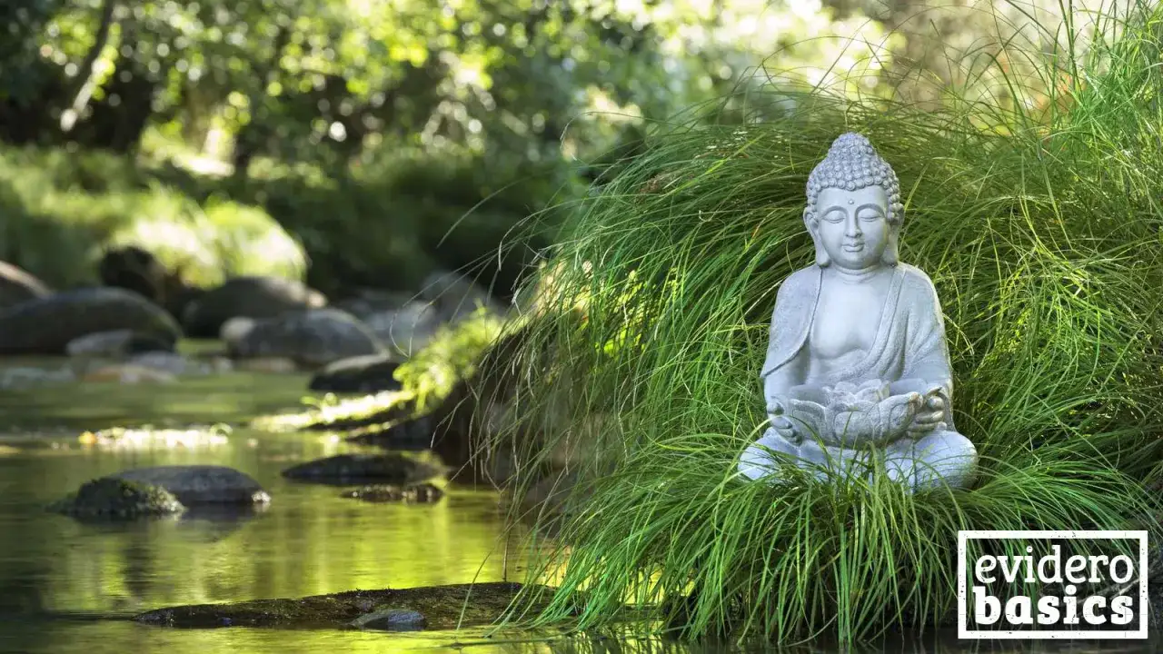 Buddha-Statue im Gras am Flussufer, ein Symbol f&uuml;r ein friedliches Buddhismus Leben.