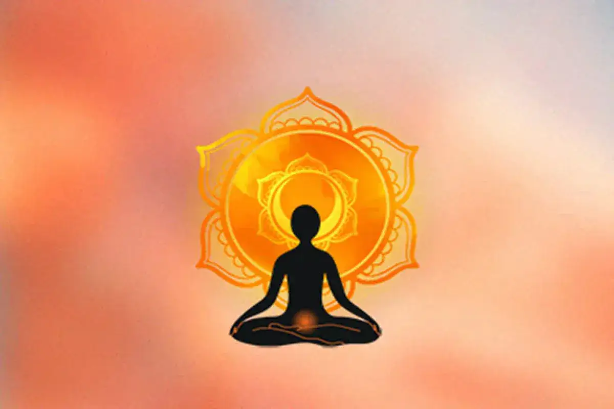 Schwarze Silhouette einer Person in Meditationshaltung vor einem leuchtenden, orangefarbenen Mandala. Fokus auf das Sakralchakra.