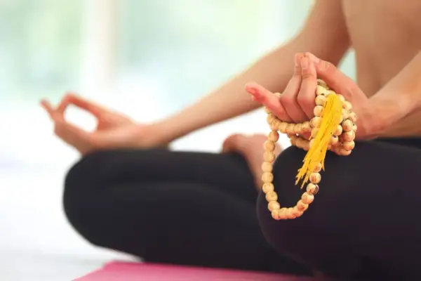 Person in Meditation, Hände halten Mala-Kette, um den perfekten Mantra finden zu können.