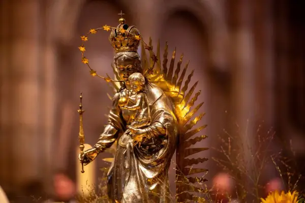 Goldene Statue der Maria mit Kind, gekrönt und mit Sternenhalo. Ein Symbol für Hoffnung und Glauben, das viele Namen trägt.