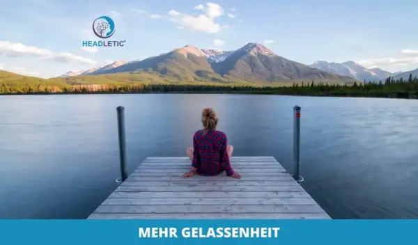 Eine Frau sitzt auf einem Steg am See, blickt auf Berge. Ähnlich gelassen wie Kardinal Ratzinger in stiller Kontemplation.